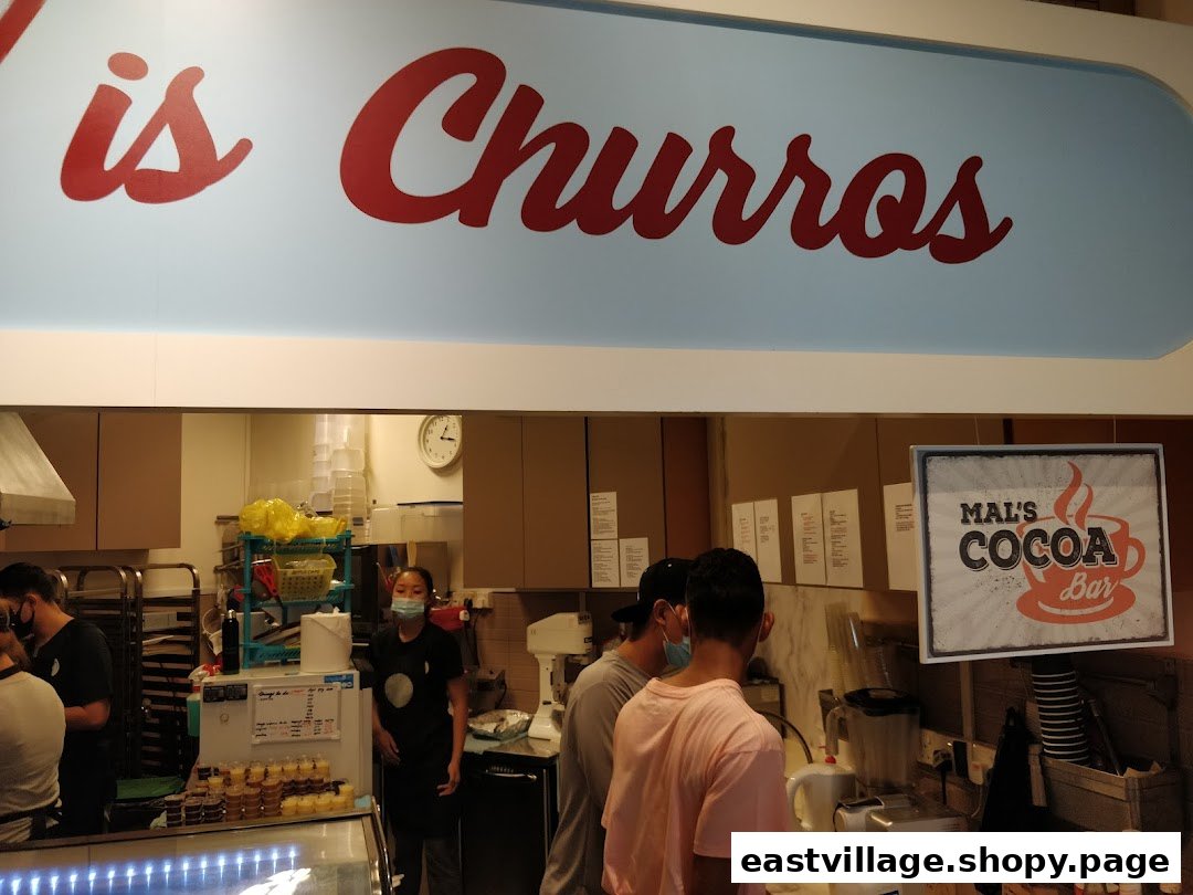 Interior view of Chulop! by The Syarifs, showing the counter, staff, customers, and 'is Churros' sign.