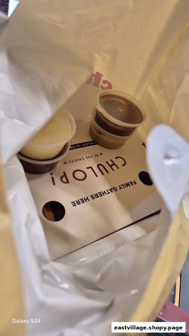 Inside a Chulop! by The Syarifs takeaway bag with food containers and branding.