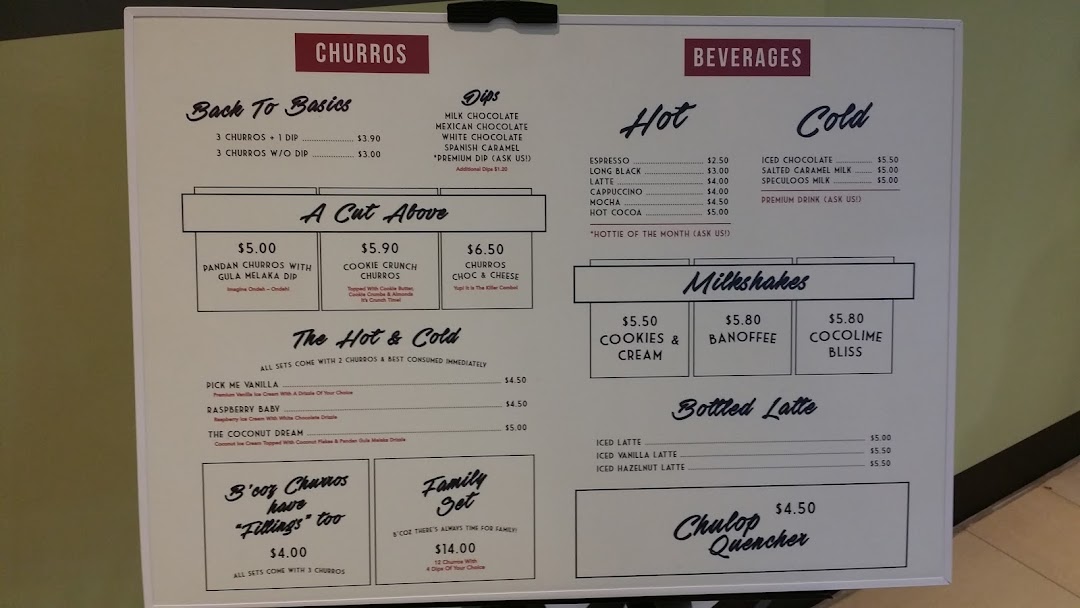 A detailed menu board displaying churros, dips, beverages, milkshakes, and lattes.