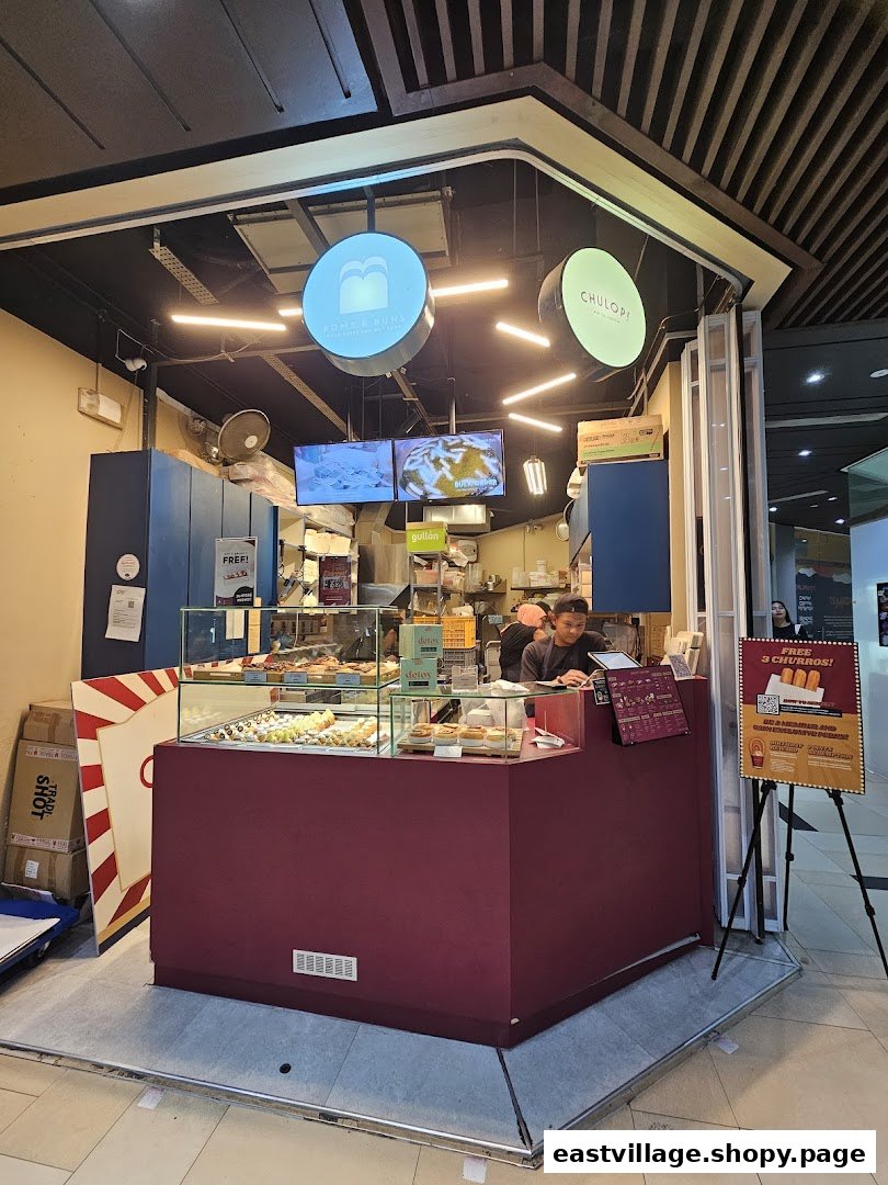A vibrant kiosk of Chulop! by The Syarifs, showcasing delicious churros and baked goods in a mall setting.