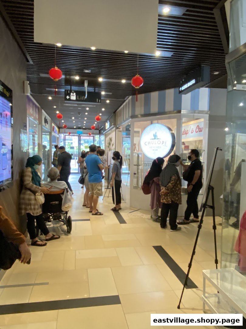 Customers queue outside Chulop! by The Syarifs, a popular shop with a distinctive circular sign.