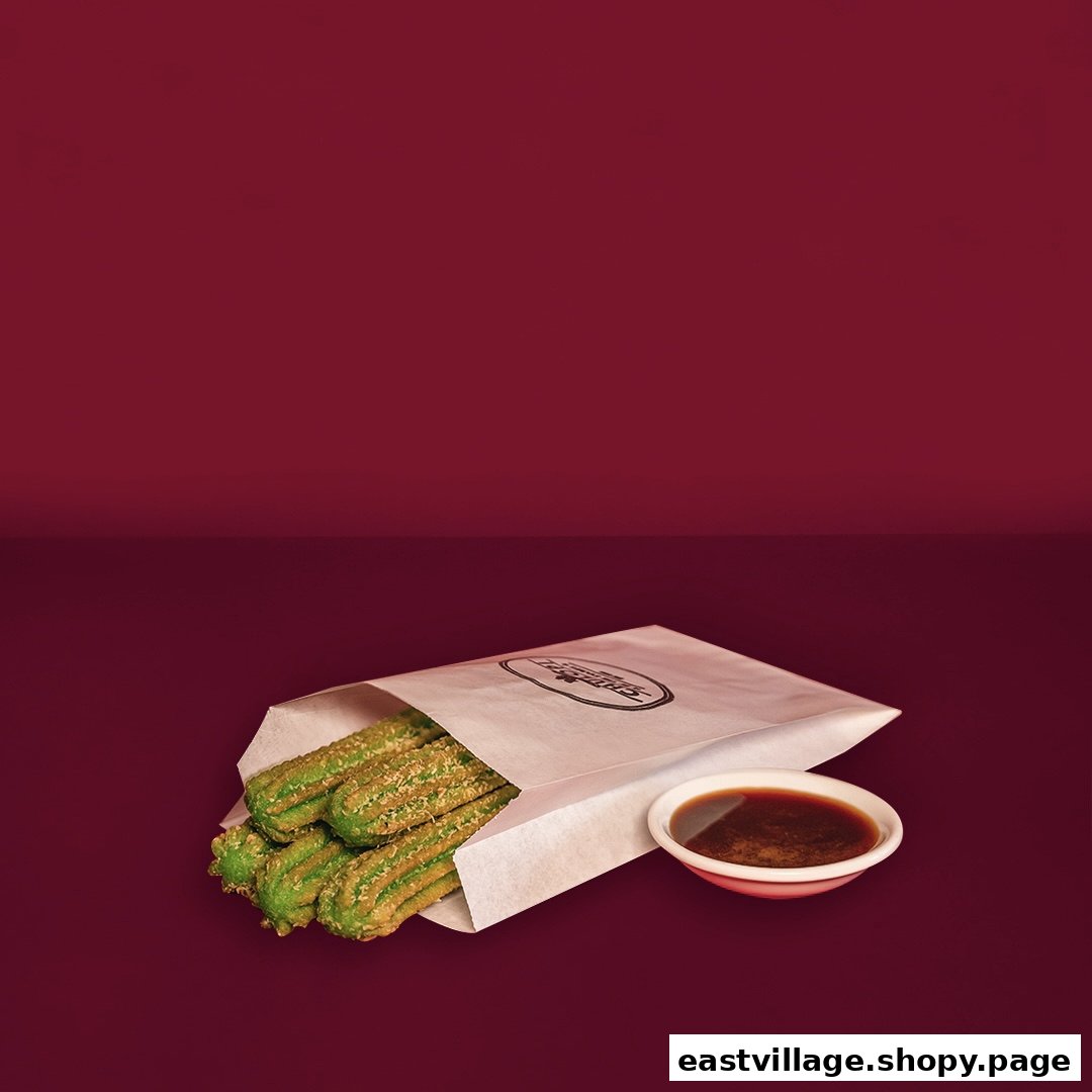 Vibrant green churros in a branded paper bag, served with a rich dipping sauce.