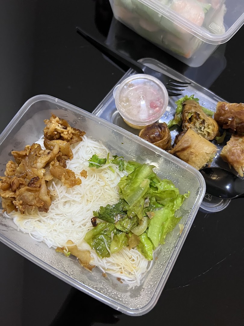 A delicious Vietnamese takeout meal featuring vermicelli noodles, spring rolls, and fresh rolls.
