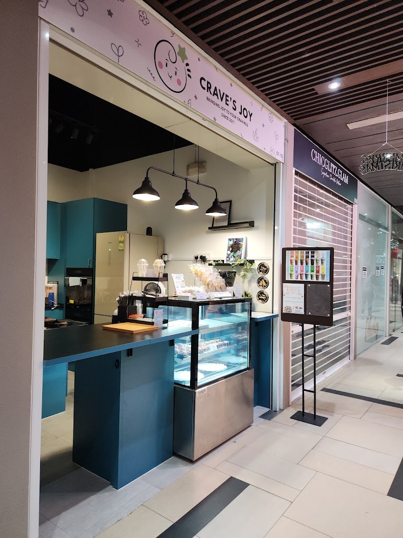 The open front of Craves Joy, a dessert shop, featuring a display case and inviting counter.