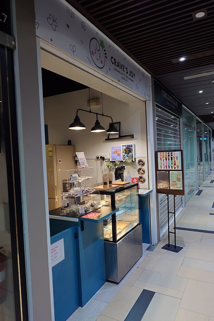 The image shows the inviting storefront of Craves Joy, a dessert and snack shop, within a mall corridor.
