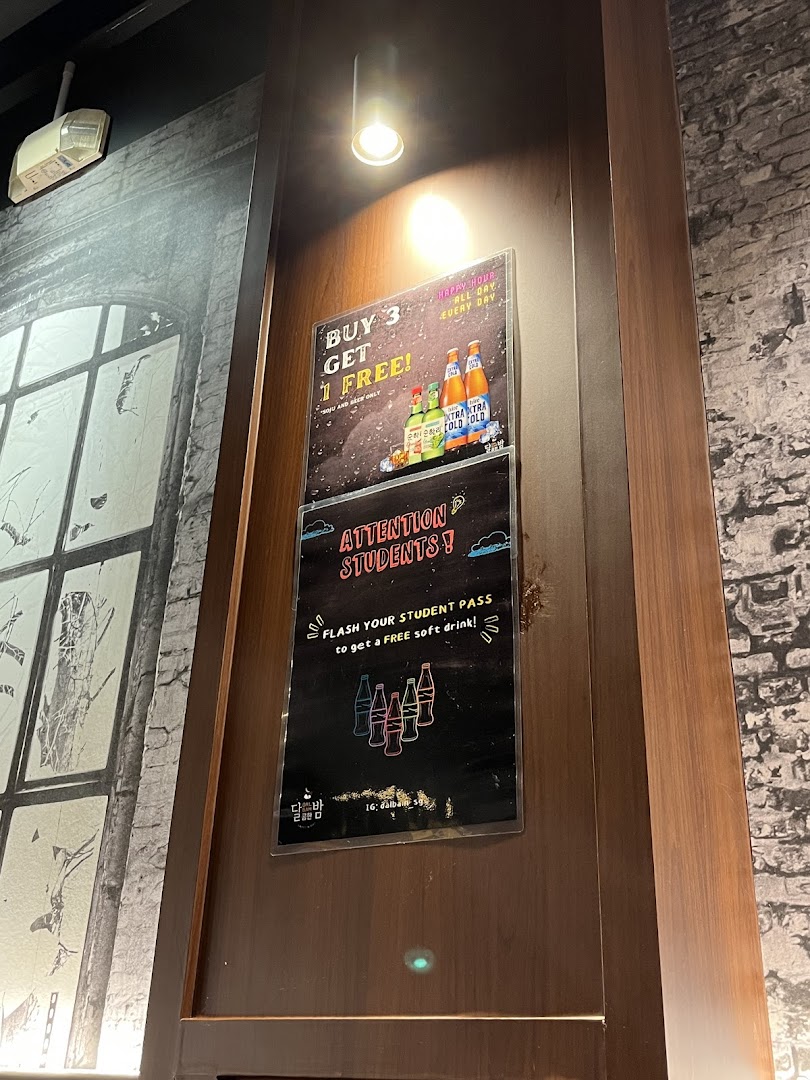 Two promotional posters displayed on a wooden pillar inside a Korean restaurant.