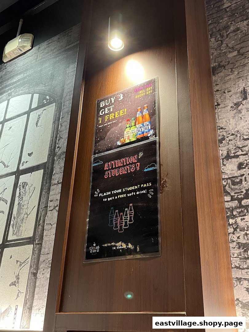 Two promotional posters displayed on a wooden pillar inside a Korean restaurant.
