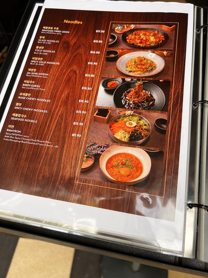 A menu page displaying various Korean noodle dishes with prices and descriptions.
