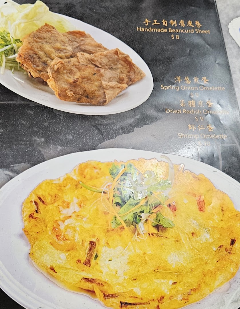 A menu page displaying two dishes: Handmade Beancurd Sheet and a Shrimp Omelette, with other omelette options listed.
