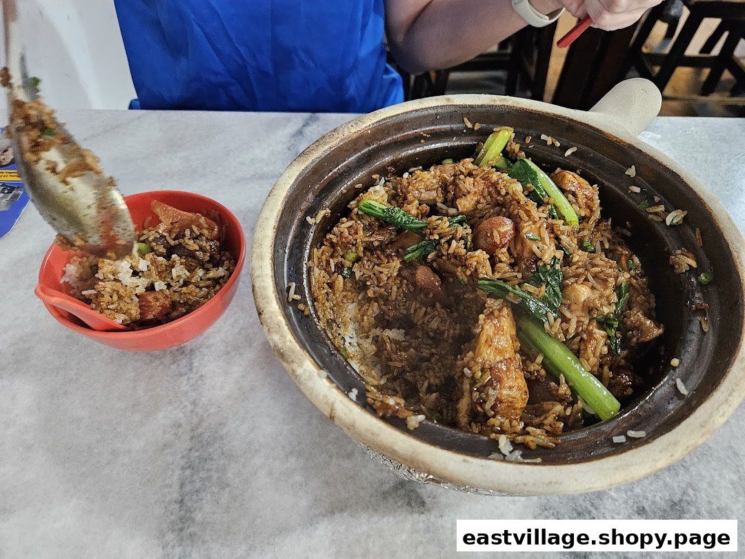 A large claypot of steaming rice with chicken and vegetables is being served into a smaller bowl.