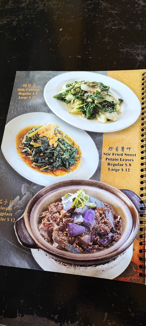 A close-up of a menu page displaying various Chinese vegetable dishes with their prices.