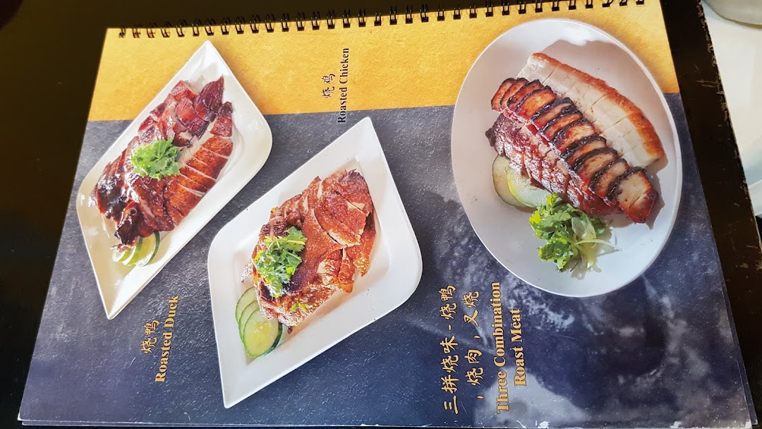 Close-up of a menu page displaying various roasted meat dishes with accompanying images.