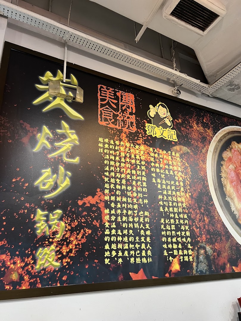 A large wall sign inside Deng Wen Ji -East Village, featuring Chinese text, a character logo, and a claypot dish.