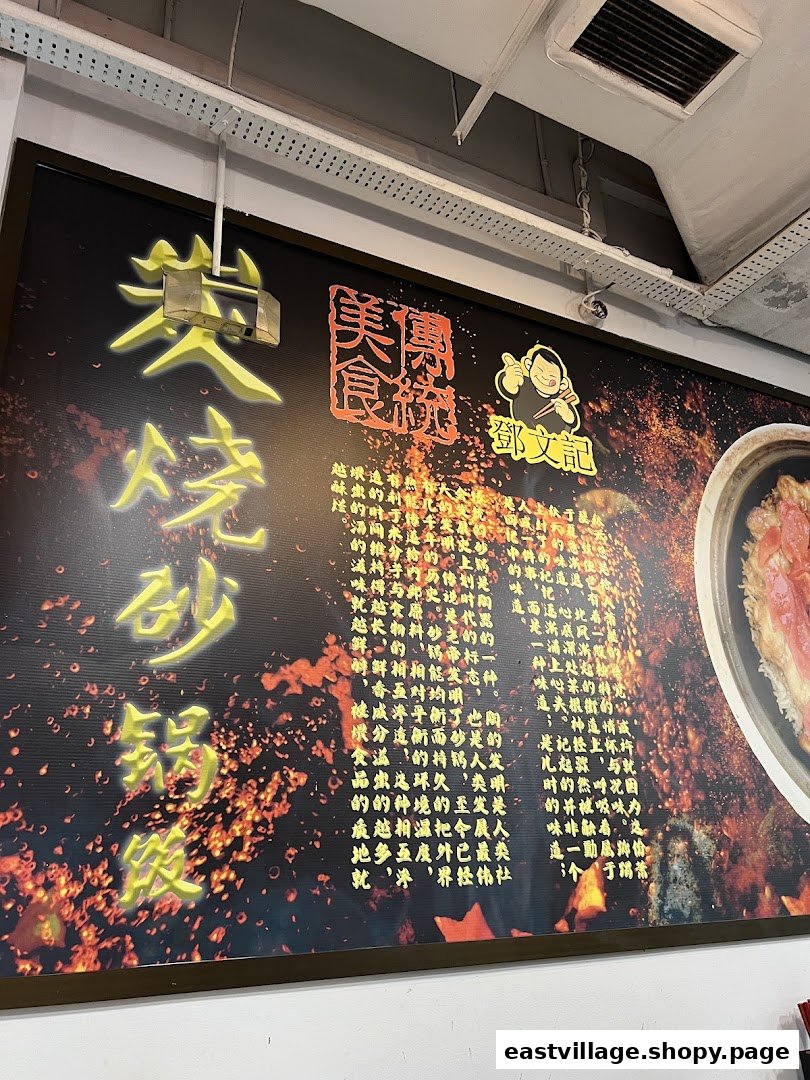 A large wall sign inside Deng Wen Ji -East Village, featuring Chinese text, a character logo, and a claypot dish.