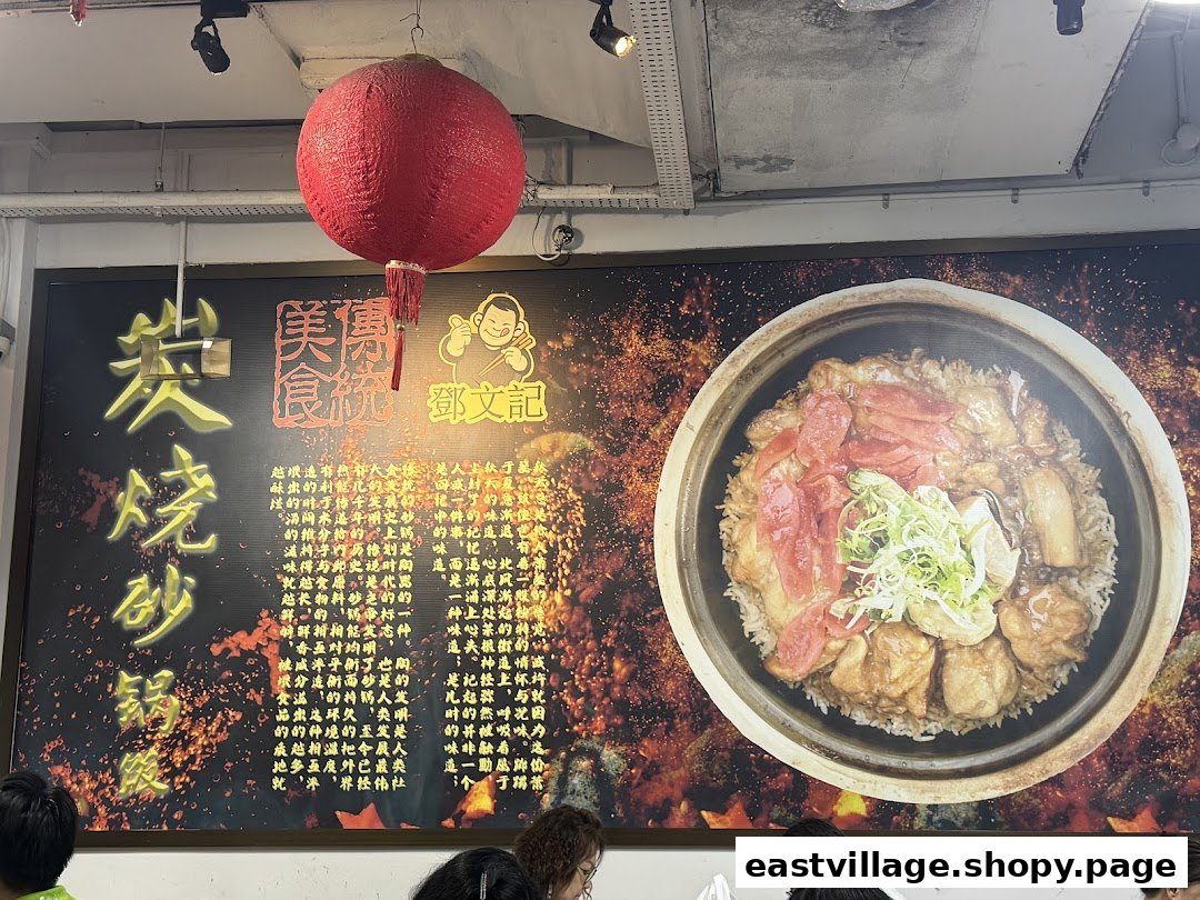 A large promotional banner inside Deng Wen Ji featuring a delicious claypot rice dish and Chinese text.