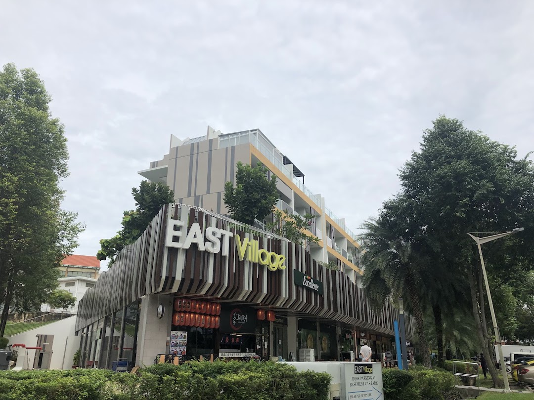 Exterior view of the modern East Village complex, showcasing its distinctive architecture and various shopfronts.