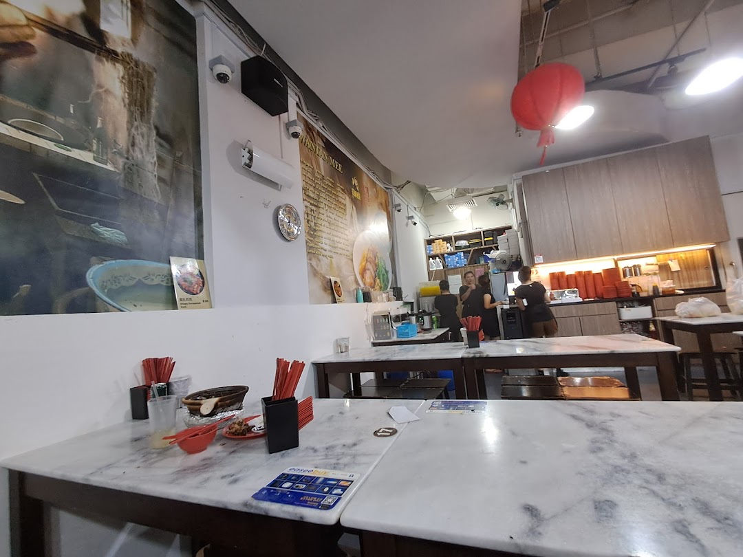 An interior view of Deng Wen Ji -East Village, featuring marble-top tables, a service counter, and wall murals.