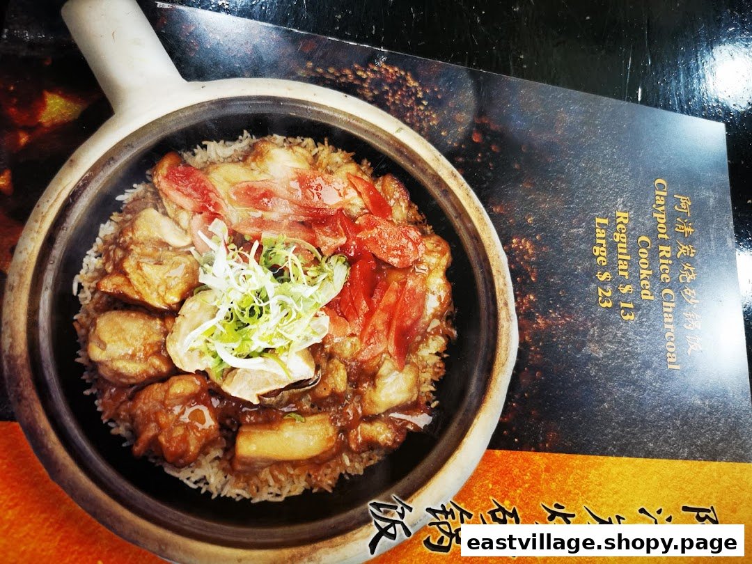 A close-up of a delicious claypot rice dish with chicken and sausage, alongside its menu description and pricing.