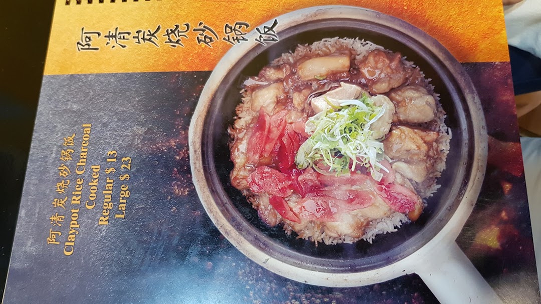 A close-up of a menu page featuring a delicious claypot rice dish with pricing.