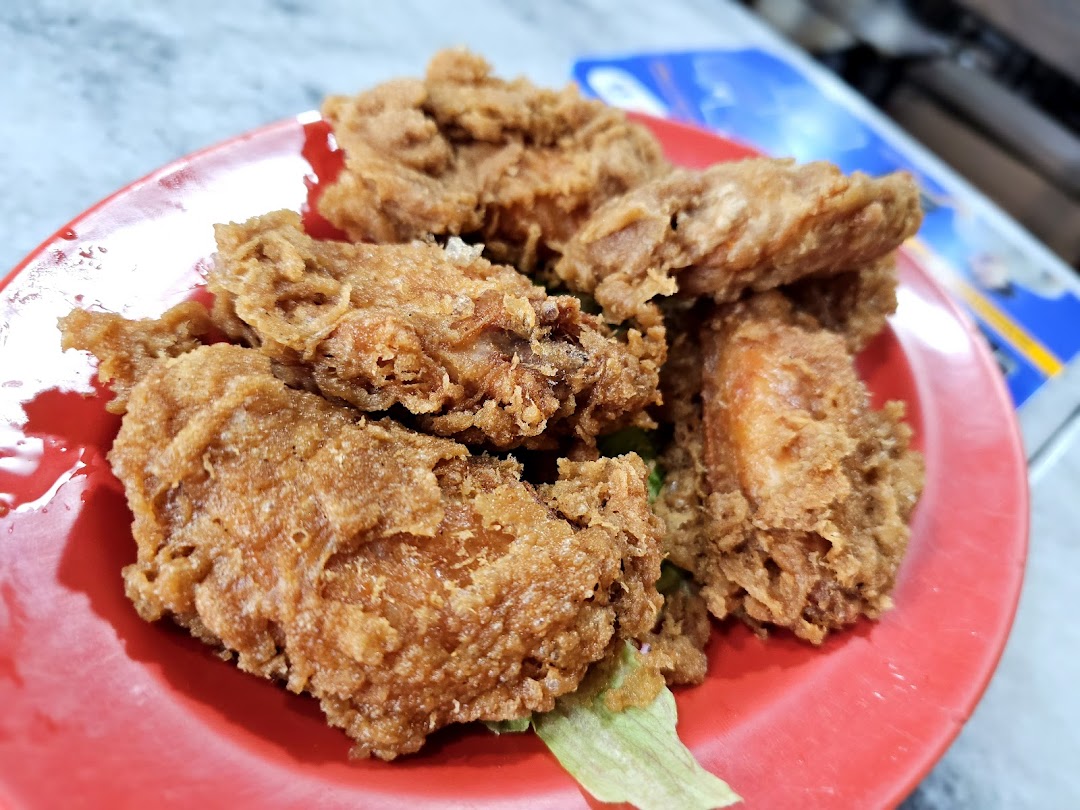 A close-up shot of crispy golden-brown fried chicken pieces served on a vibrant red plate.