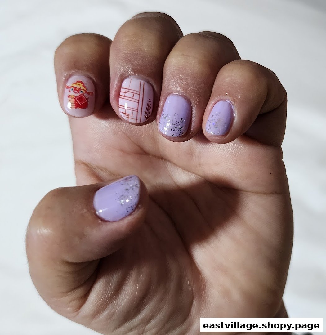 A hand displaying beautifully manicured nails with lavender polish, glitter, and intricate designs.