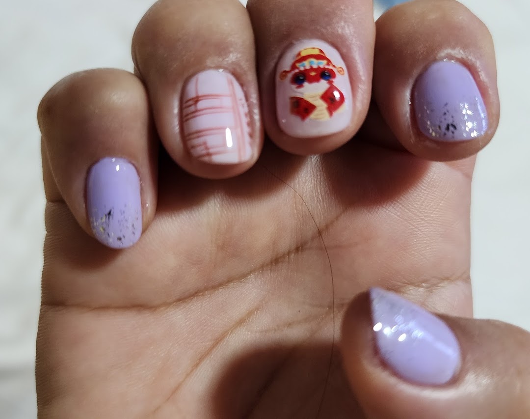 Close-up of a hand showcasing beautifully manicured nails with lavender polish and intricate designs.