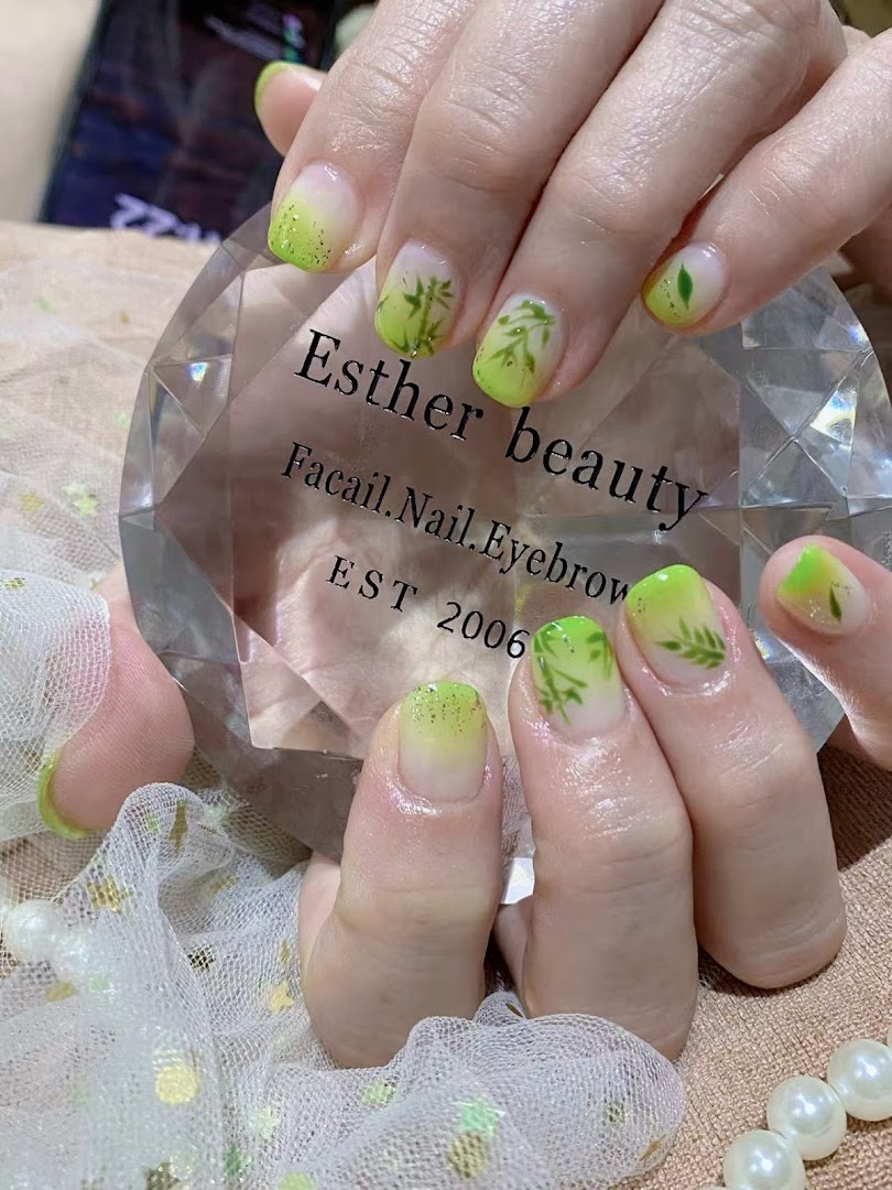 Close-up of hands showcasing a fresh green gradient nail design with delicate leaf art.