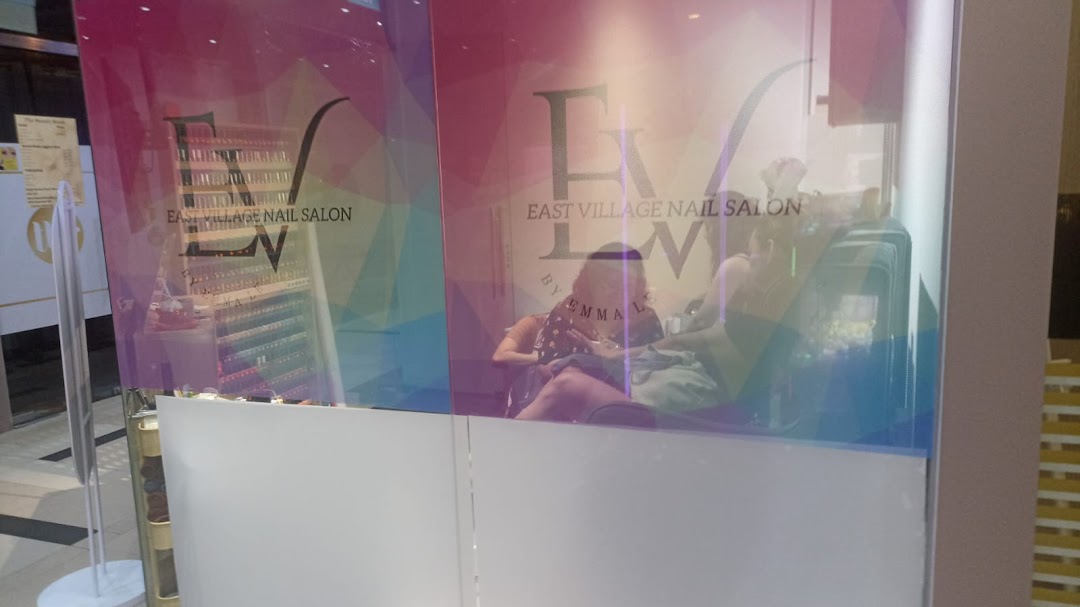 The vibrant storefront of EV Nail Salon, showcasing customers enjoying services inside.