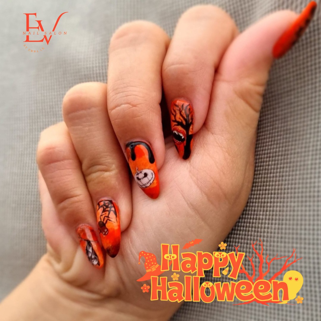 A hand showcasing vibrant Halloween-themed nail art with pumpkins, spiders, and spooky designs.
