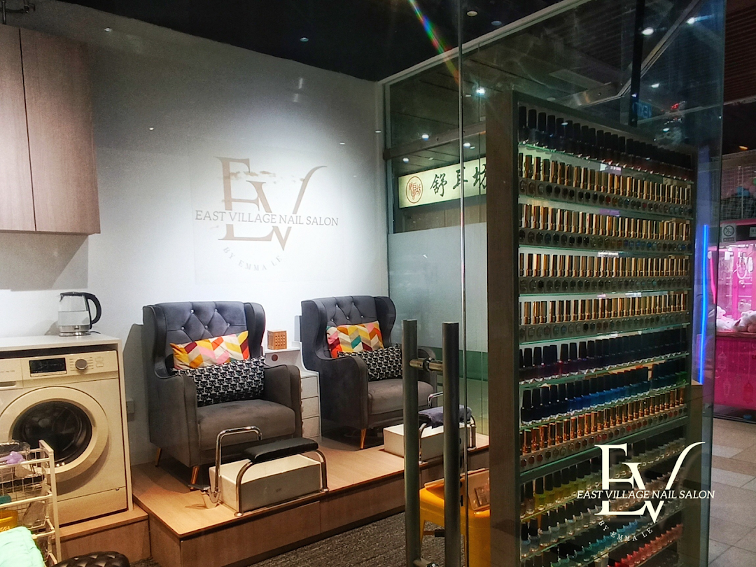 Interior of EV Nail Salon featuring comfortable seating, a washing machine, and a vast display of colorful nail polishes.