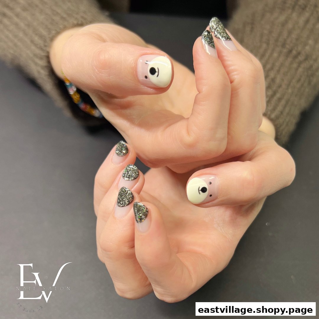 Close-up of hands showcasing a creative manicure with glitter tips and cute bear nail art.