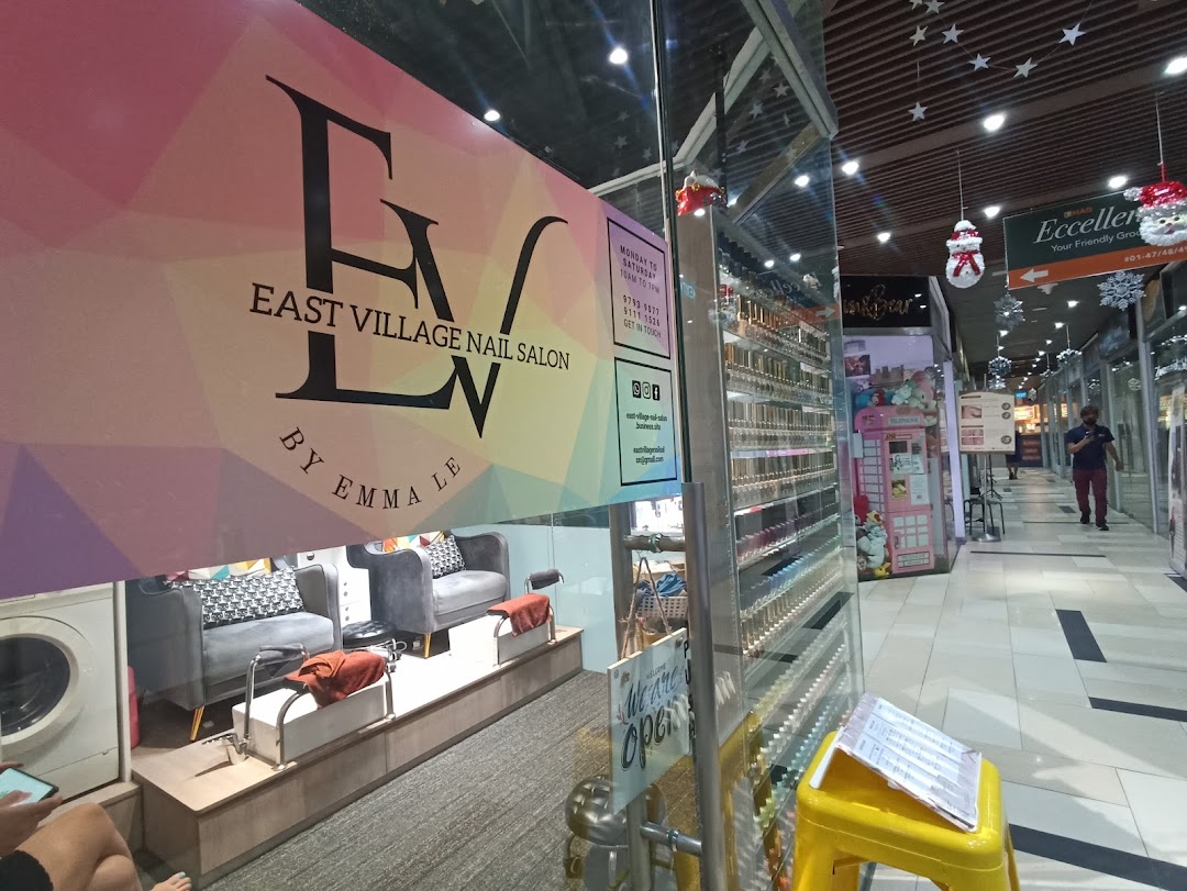 The storefront of EV Nail Salon, showcasing its logo, interior, and inviting entrance.