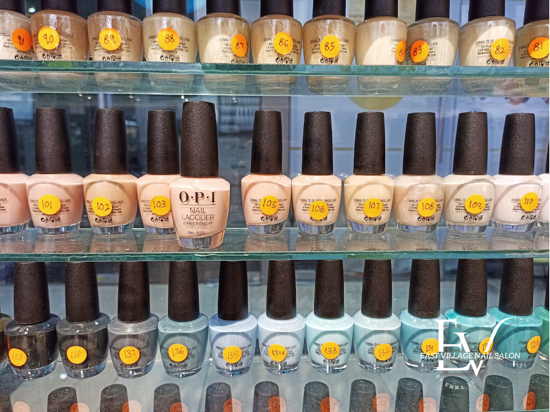 A close-up view of various OPI nail lacquer bottles displayed on glass shelves at a nail salon.