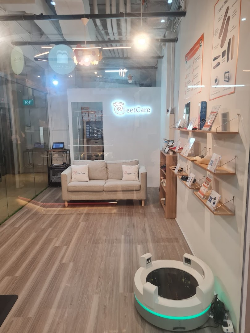 Interior view of FeetCare East Village, showcasing a comfortable waiting area, foot scanning equipment, and product displays.