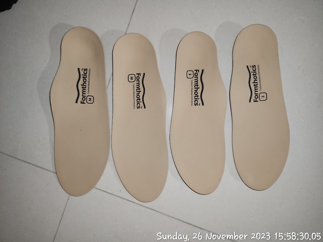 Four pairs of Formthotics custom medical orthotics insoles are displayed on a tiled surface.