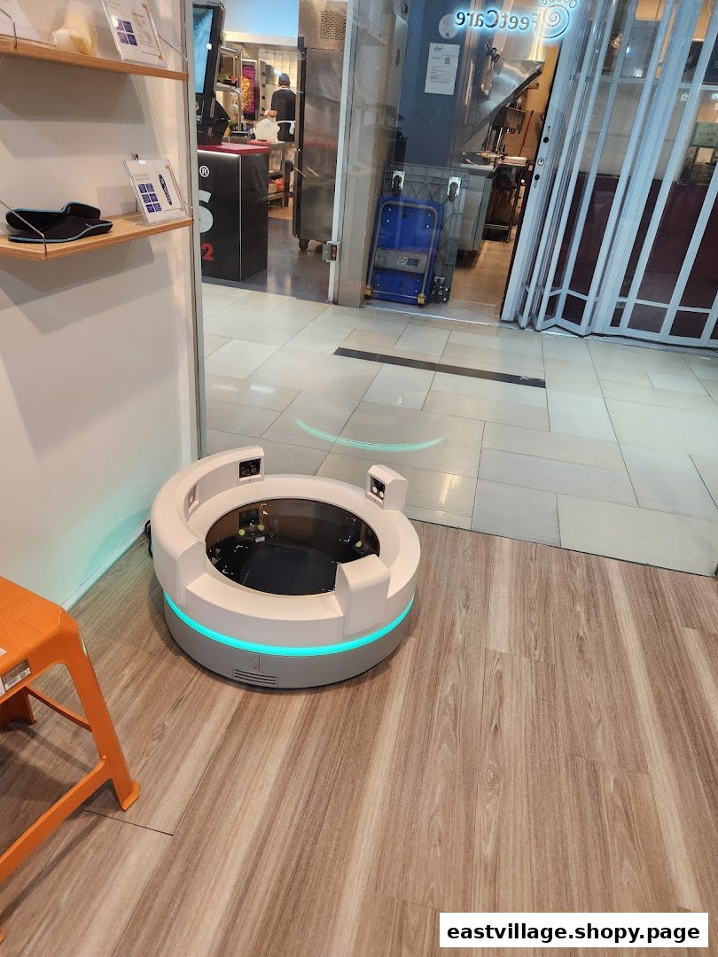 A modern circular foot scanning device with blue light, an orange stool, and product displays inside FeetCare East Village.