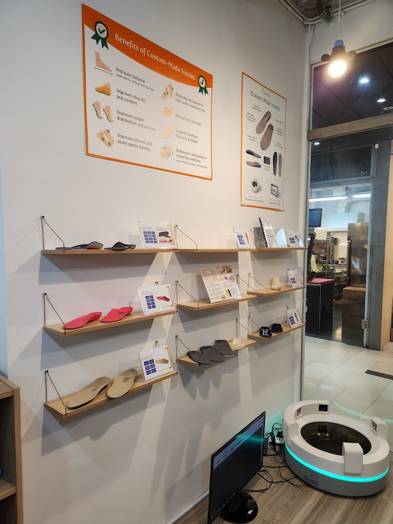 Interior view of FeetCare East Village, showcasing custom insoles, informational displays, and a foot scanning device.