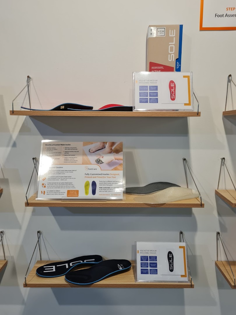 Shelves displaying various insoles and informational signs about custom foot care solutions at FeetCare.