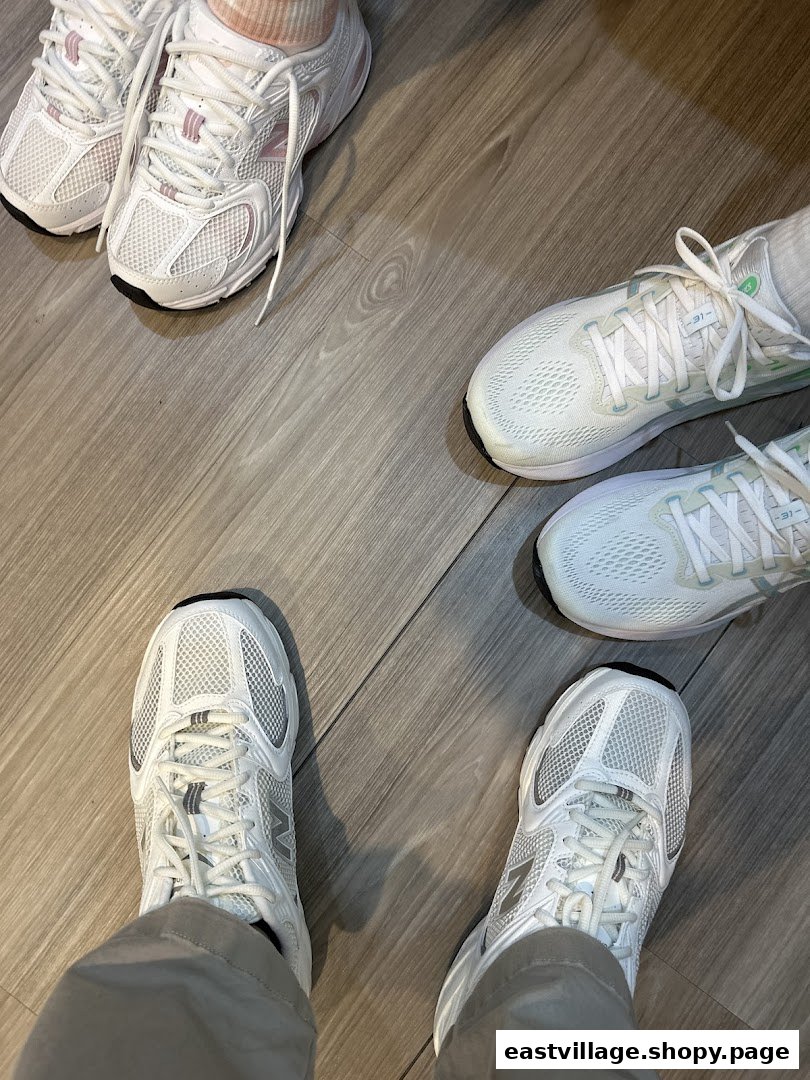 Multiple pairs of feet wearing various white athletic shoes on a wooden floor, showcasing footwear options.