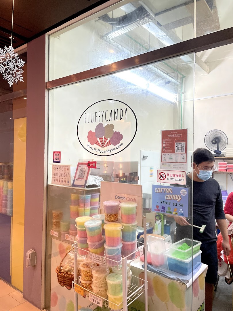 Fluffy Candy storefront displaying colorful cotton candy products and a staff member.