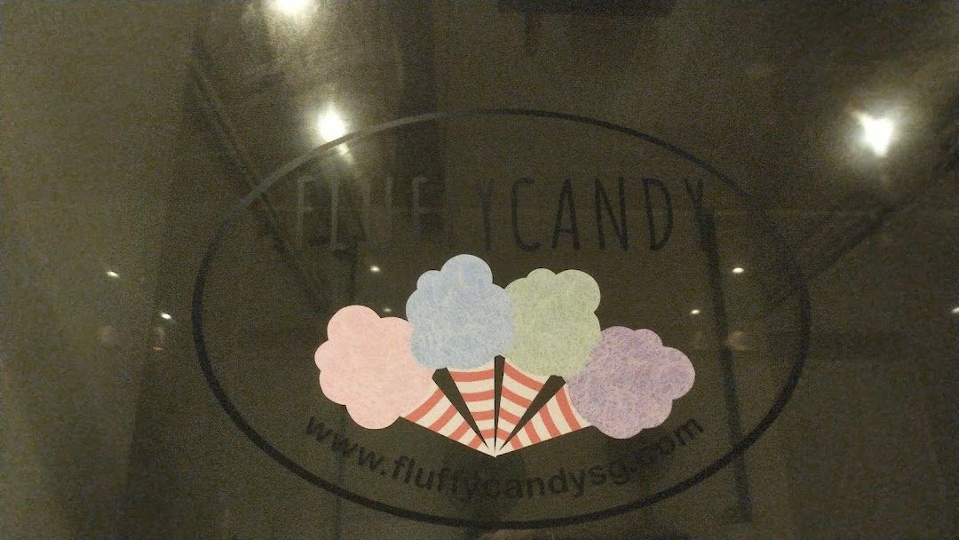 The Fluffy Candy shop logo featuring colorful cotton candy designs on a glass entrance.