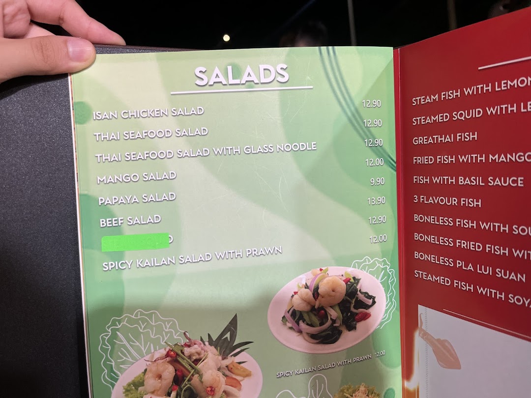 A close-up view of GreaThai's menu, featuring a variety of fresh salads and fish dishes.