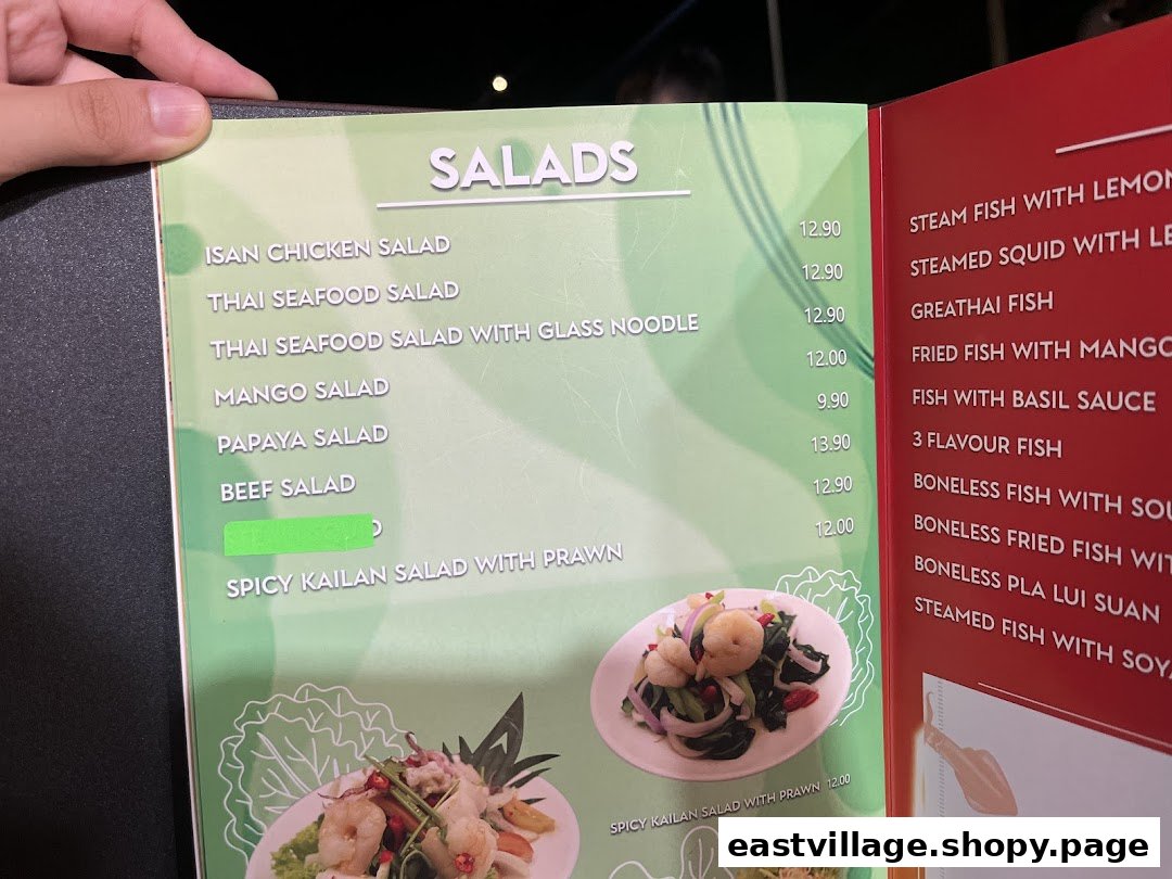 A close-up view of GreaThai's menu, featuring a variety of fresh salads and fish dishes.
