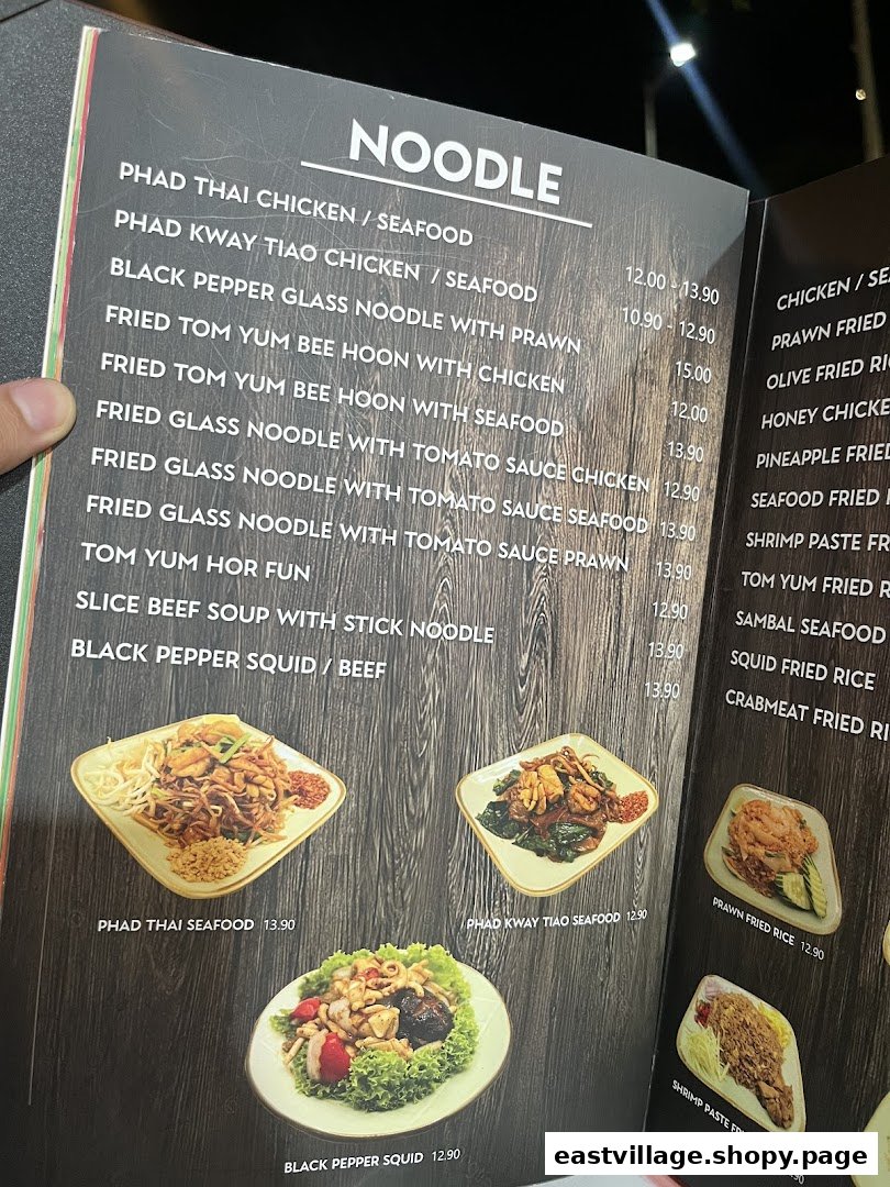 A close-up view of a Thai restaurant menu featuring noodle dishes and prices.