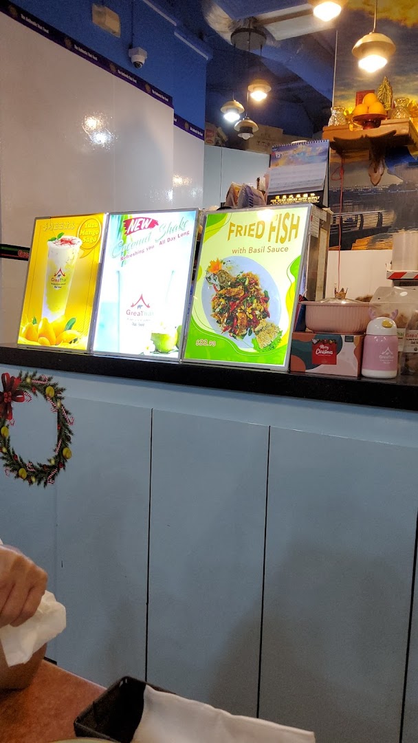 A counter inside GreaThai featuring illuminated display boards showcasing food and drink items.