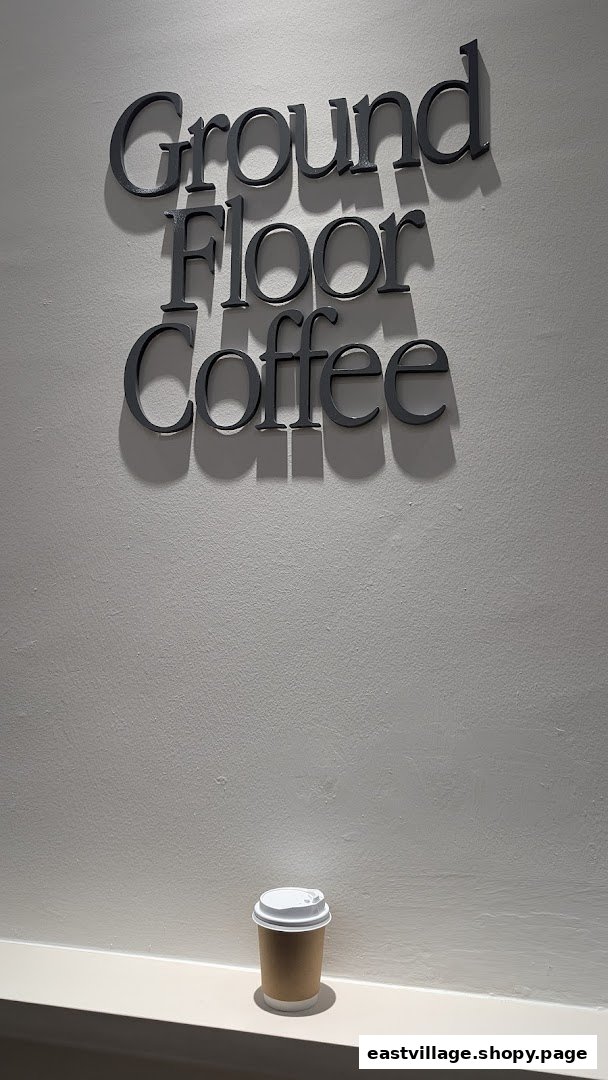 The 'Ground Floor Coffee' sign is displayed on a wall, with a coffee cup resting below it.