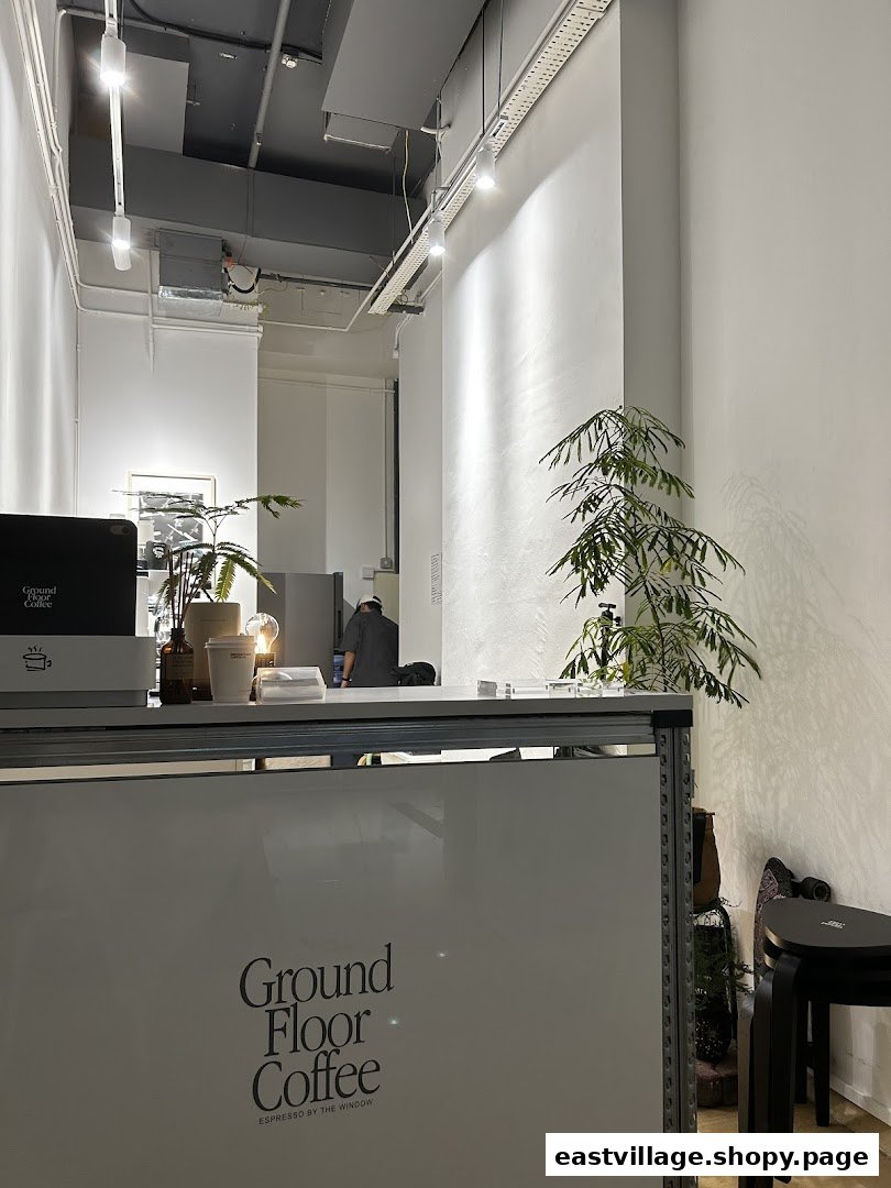 An interior view of Ground Floor Coffee, featuring the minimalist counter and a staff member.