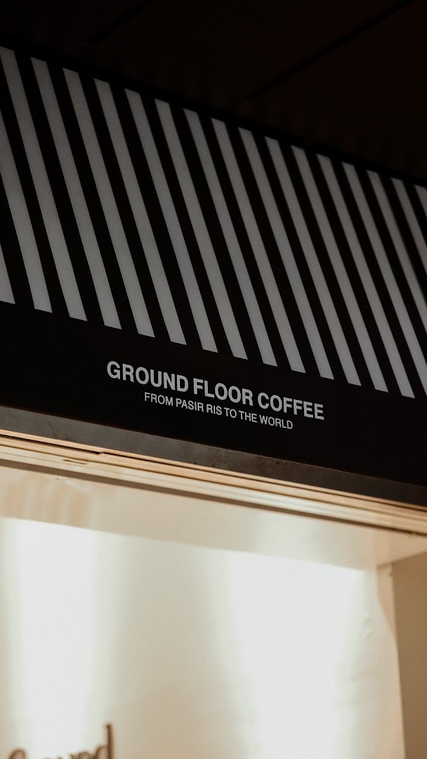 Close-up of Ground Floor Coffee's distinctive black and white striped awning with its name and slogan.
