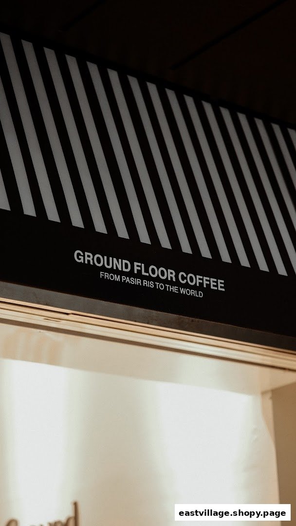 Close-up of Ground Floor Coffee's distinctive black and white striped awning with its name and slogan.