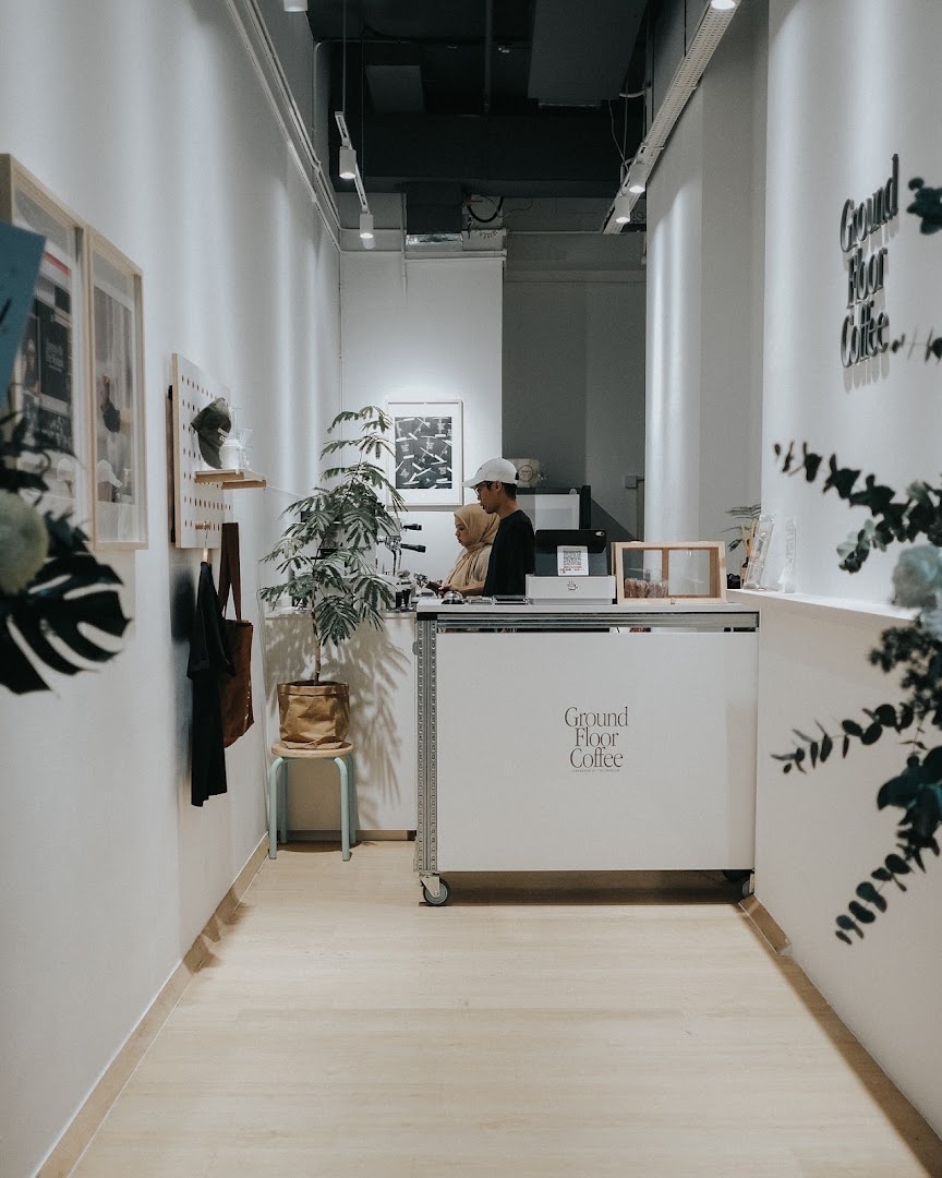 Interior view of Ground Floor Coffee, featuring the minimalist counter and staff preparing drinks.